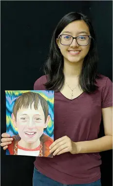  ?? Submitted photo ?? ■ Texas High School student Victoria Van poses with one of the portraits she made depicting an orphan in Afghanista­n. THS art club members worked with The Memory Project to deliver 15 portraits to orphans.