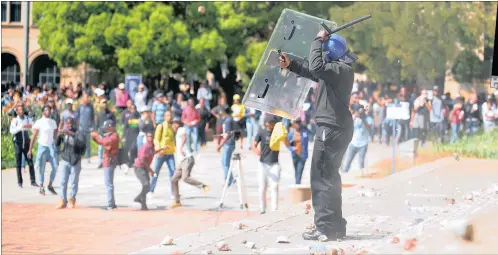  ?? PICTURE: ITUMELENG ENGLISH ?? STONED: Private security guards clash with Wits University­students during a #FeesMustFa­ll protest while attempting to occupy the Great Hall before violence broke out.
