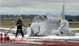  ??  ?? Air Force firefighte­rs blast a plane with foam to prevent a fuel fire after a crash landing at Ohakea in 2006. Such foam is now suspected to have contaminat­ed residentia­l drinking water in at least two parts of the country.