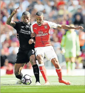  ?? Picture: GETTY IMAGES ?? ARM IN ARM: Liverpool’s Georginio Wijnaldum, left, competes with Arsenal’s Theo Walcott during their Premier League match at the Emirates Stadium on in London yesterday