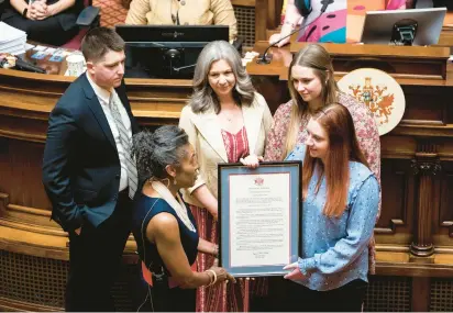  ?? BILLY SCHUERMAN/STAFF ?? Abigail Zwerner is handed a copy of senate resolution 104 by Lt. Gov. Winsome Earle-Sears at the Virginia State Capitol on Wednesday. Zwerner was honored for heroic actions inside her classroom Jan. 6 at Richneck Elementary School.