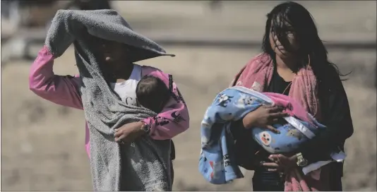  ?? CUBILLOS AP PHOTO/ARIANA ?? Women carry babies after arriving by boat from La Bulla Loca mine, which collapsed, in La Paragua, Bolivar state, Venezuela, on Friday.