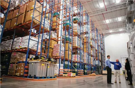  ?? Mark Mulligan / Houston Chronicle ?? Above: Preferred Freezer’s 10-million-cubic-foot cold storage facility is kept at minus 4 degrees. The building hosts 25,000 pallet positions. Below: Kroger e-commerce clerk Antonio Valderas picks out items from an aisle as he fills ClickList online...