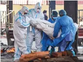  ?? — PTI ?? Family members, wearing PPE, perform last rites of a Covid-19 victim at Nigambodh Ghat crematoriu­m in New Delhi on Friday.