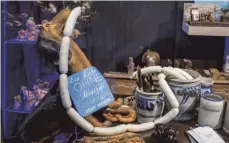  ?? FOTO: DPA ?? Plastikdac­kel mit Weißwursts­chlange: Es gibt nichts, was es nicht gibt im Dackelmuse­um, auch der Brotzeitti­sch ist reichlich gedeckt.