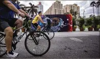  ?? DAMON HIGGINS / THE PALM BEACH POST ?? Two cyclists pass a barricade on Flagler Drive in West Palm Beach on Wednesday.