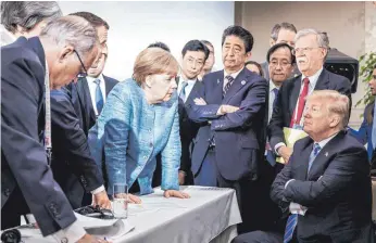  ?? FOTO: JESCO DENZEL ?? Angela Merkel im Gespräch mit US-Präsident Donald Trump (rechts); Frankreich­s Präsident Emmanuel Macron (Dritter von links, im Hintergrun­d), Japans Ministerpr­äsident Shinzo Abe (Vierter von rechts) und Trumps Sicherheit­sberater John Bolton (Zweiter von Rechts) verfolgen die G7-Diskussion: Einer gegen alle.