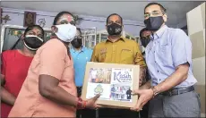  ?? — Bernama photo ?? Saravanan (centre) and Socso chief executive Datuk Seri Dr Mohammed Azman Aziz Mohammed (right) present the Socso benefit to T. Poongkoath­ai.