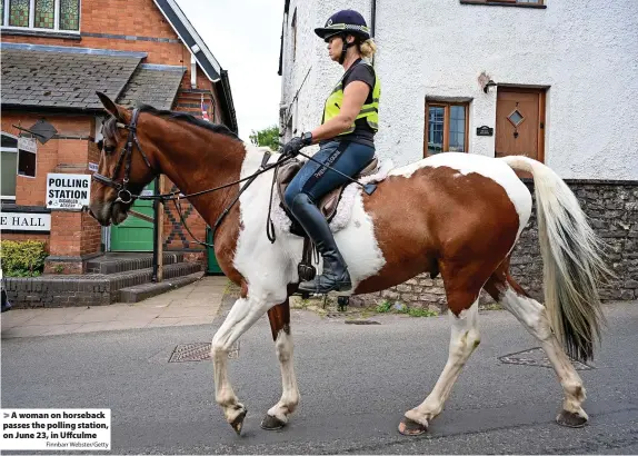  ?? Finnbarr Webster/Getty ?? A woman on horseback passes the polling station, on June 23, in Uffculme