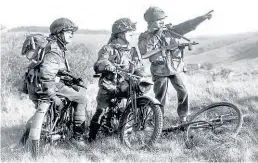  ??  ?? Two paratroope­rs on Royal Enfield Flying Fleas, and a third on a bicycle, discuss their next move. Many of them were in action on D-Day.