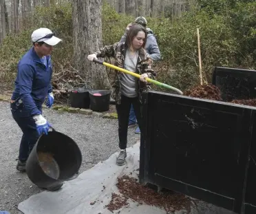  ?? The Sentinel-Record/Grace Brown ?? ■ Garvan Woodland Gardens employees Shaley Mahan, right, and Sharla St. Peter work to lay mulch in flower beds at the garden in preparatio­n for spring, as another worker spreads the mulch, on Thursday.