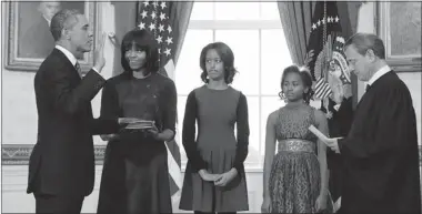  ?? LARRY DOWNING/ AFP/GETTY IMAGES ?? U.S. President Barack Obama takes the oath of office from Supreme Court Chief Justice John Roberts as wife Michelle and daughters Malia, left, and Sasha look on in the Blue Room of the White House in Washington on Sunday.