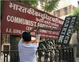  ?? — PRITAM BANDYOPADH­YAY ?? A Hindu Sena activist vandalises the signboard of the Communist Party of India ( Marxist) HQ in New Delhi on Tuesday as the group protested against the killing of a RSS activist in Kerala.