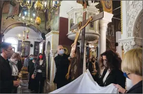  ?? (AP/Yorgos Karahalis) ?? Orthodox faithful take part Friday in a ceremony of the Deposition of Jesus Christ at Saint Catherine church in Athens.