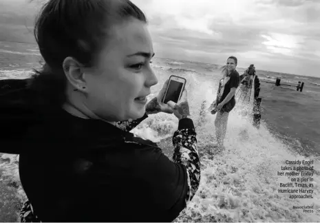  ?? Associated Press ?? Cassidy Engel takes a photo of her mother Friday on a pier in Bacliff, Texas, as Hurricane Harvey approaches.