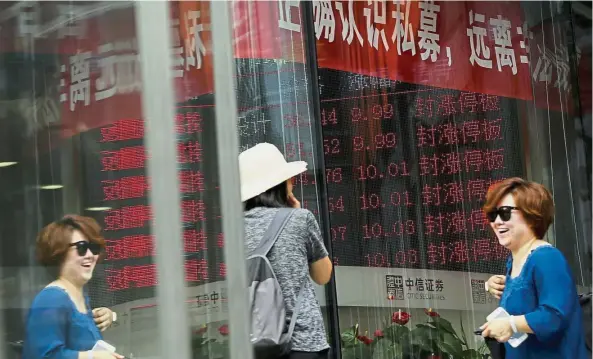  ?? – AP ?? The China factor: A brokerage house displaying stock trading index in Beijing yesterday. Global stock benchmark provider MSCI has made a long-awaited decision to add mainland China-listed shares to its widely followed stock indexes. MSCI says it’s...