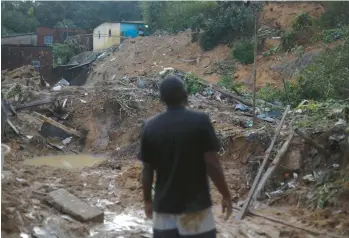  ?? SERGIO MARANHAO/GETTY-AFP ?? Deadly Brazilian floods: A man glares Tuesday at the site of a landslide in the Ibura neighborho­od of Recife, Brazil. The death toll from torrential rains that triggered floods and landslides in northeaste­rn Brazil rose to 100, officials said, as emergency workers searched for more victims. The low-lying metropolit­an region is set at the delta of three rivers.