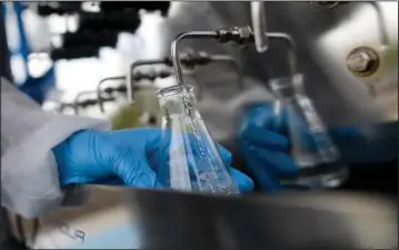  ?? (File Photo/AP/Gregory Bull) ?? An engineer fills a container with recycled water May 8, 2015, at the Advanced Water Purificati­on Facility in San Diego.