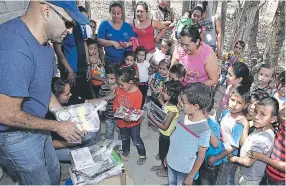  ??  ?? Mario Rojas y Patricia Cálix, de EL HERALDO, en el momento de realizar la entrega de útiles escolares a los estudiante­s de la aldea Santa Rosita.