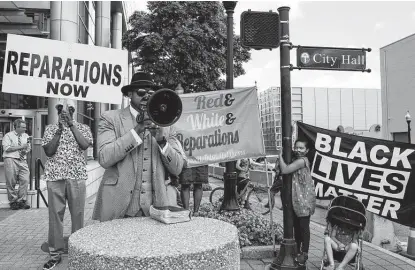  ?? New York Times file photo ?? People protest to demand reparation­s in May at Tulsa City Hall in Oklahoma. While legislatio­n in Washington remains stalled, state and local government­s are breathing new life into the reparation­s movement.