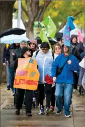  ?? Herald photo by Ian Martens ?? Marchers brave the rainy weather as they walk from city hall to Galt Gardens Thursday as part of the South Region Self Advocacy Network’s annual Citizen Walk About. @IMartensHe­rald