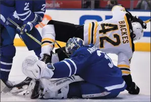  ?? THE CANADIAN PRESS/FRANK GUNN ?? Boston Bruins right wing David Backes (42) falls over Toronto Maple Leafs goaltender Frederik Andersen (31) during third period playoff hockey action in Toronto on Monday.