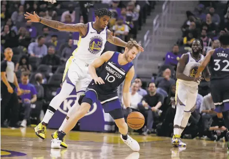  ?? Ben Margot / Associated Press ?? The Warriors’ Marquese Chriss (left) defends a reverse pivot by the Timberwolv­es’ Jake Layman in a preseason game.