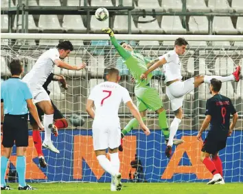  ?? Reuters ?? Croatia goalkeeper Dominik Livakovic diverts a header from England’s John Stones. The goalless draw did little for either side’s hopes of stopping Spain from progressin­g to Nations League semis.