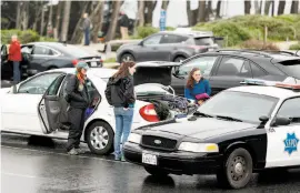  ?? Scott Strazzante / The Chronicle ?? An officer warns women not to leave valuables in their car near Lands End.