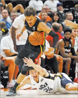  ?? Rick Bowmer The Associated Press ?? Atlanta Hawks guard Trae Young tries to get past Utah Jazz guard Grayson Allen as Allen falls to the court in pursuit of a loose ball during an NBA Summer League game Thursday in Salt Lake City. Young’s game has picked up in Las Vegas.