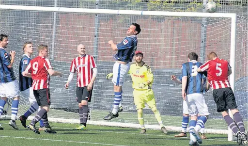  ??  ?? ●●Mellor (in red and white) put pressure on the Rochdalian­s goal during the weekend’s Premier Division clash