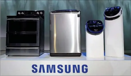  ?? ETHAN MILLER/GETTY IMAGES/AFP ?? Samsung’s Automatic Top Loading Washing Machine with ACTIVWash+ (second left) on display at a press event for Samsung at the Mandalay Bay Convention Center for the 2015 Internatio­nal CES on January 5, 2015, in Las Vegas, Nevada.