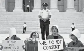  ?? Andrew Harrer / Bloomberg ?? Demonstrat­ors dressed in “Handmaid's Tale” attire appeared at the U.S. Supreme Court on Brett Kavanaugh’s first day as a justice.