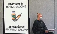  ?? ANGELA PETERSON / MILWAUKEE JOURNAL SENTINEL ?? Morgan Snyder, 22, of Milwaukee, a behavioral health technician, waits to get the COVID-19 vaccine at the Wisconsin Center on Thursday. She was among the eligible city employees who were getting the first vaccine. She and others will return in a few weeks for their second dose.