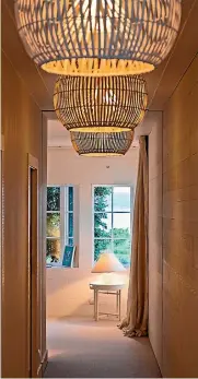  ??  ?? A line of oversized cane lampshades add drama to the hallway in this Hawke’s Bay home.
