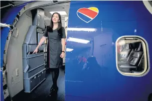  ??  ?? Ami Martin, a flight attendant for Southwest Airlines, waits for passengers boarding a flight at Love Field in Dallas.