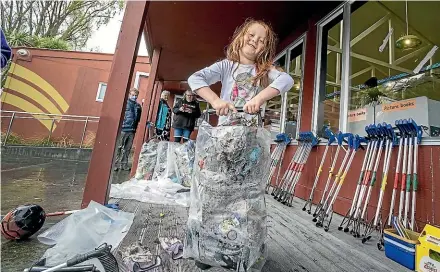  ?? WARWICK SMITH/STUFF ?? Astrid Grace, 5, struggles to lift the bag of rubbish her family collected on World Cleanup Day.