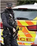  ??  ?? GUARD Armed police at raid house