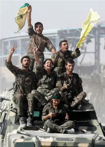  ?? © rtr ?? Leden van de Syrische Democratis­che
Krachten (SDF) vieren de overwinnin­g.