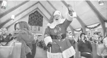  ??  ?? Santa Tom greets visitors during a holiday celebratio­n at Cloverdale School. Myers works for the US Defence Department by day.