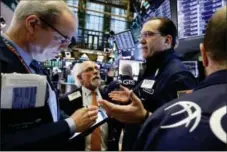  ?? RICHARD DREW — THE ASSOCIATED PRESS FILE ?? Specialist Anthony Matesic, right, works with traders on the floor of the New York Stock Exchange.