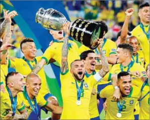  ?? JUAN MABROMATA/AFP ?? Brazil’s Dani Alves and teammates celebrate with the trophy after beating Peru in the Copa America final at Maracana Stadium in Rio de Janeiro, Brazil, on Sunday.