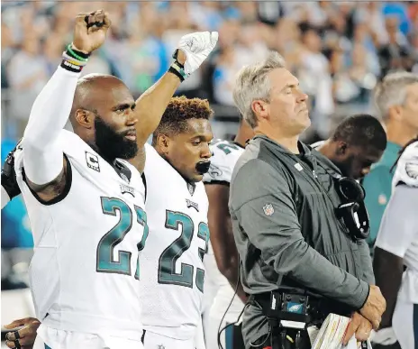  ?? THE ASSOCIATED PRESS ?? Eagles players Malcolm Jenkins, left and Rodney Mcleod raise their fists during the national anthem before a game last season.