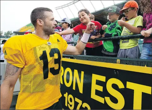  ?? DAVID BLOOM/POSTMEDIA NETWORK ?? Quarterbac­k Mike Reilly fist-bumps visitors from a kids summer camp following an Edmonton Eskimos practice last summer.