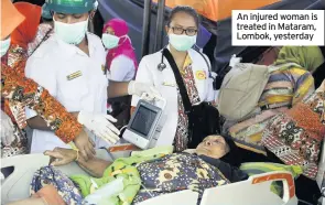  ??  ?? An injured woman is treated in Mataram, Lombok, yesterday