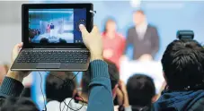  ?? /123RF ?? Digital convergenc­e: Reporters take photos and capture videos at a media conference. In the past, news groups competed with each other, but cooperatio­n has now become more critical.