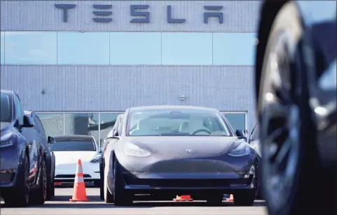  ?? Associated Press ?? A long line of unsold 2021 Model 3 sedans sits at a Tesla dealership Jan. 24 in Littleton, Colo.