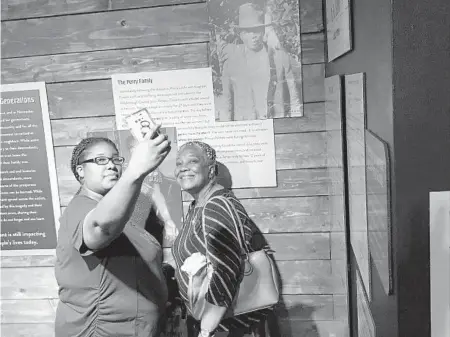  ?? STEPHEN HUDAK/ORLANDO SENTINEL ?? Lynching victim July Perry’s descendant­s, Janiece Nelson, left, and her mother, Janice Nelson, take a selfie near his photograph at the Orange County History Center. The center’s exhibit marking the centennial observance of the Ocoee Election Day massacre of 1920 runs through Feb. 14.