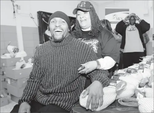  ??  ?? Close with mom: Ray Lewis and his mother, Sunseria Smith, give out turkeys at a Baltimore high school before Thanksgivi­ng. He has urged her to adopt healthier habits.