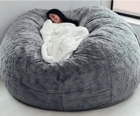  ?? LOVESAC ?? One of Lovesac's larger beanbag models with a blanketed adult in the middle.